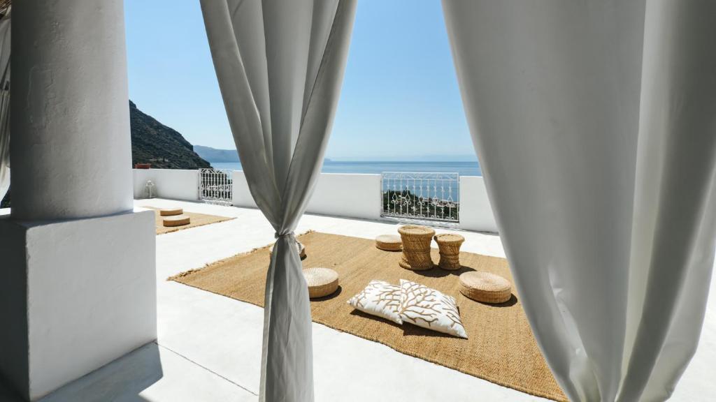 a room with a view of the ocean through curtains at Salina Castel Vinci in Rinella