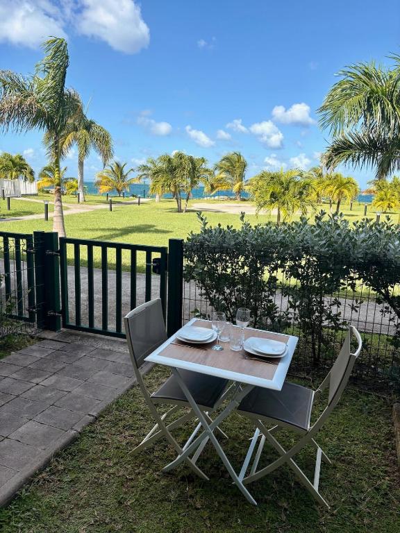 a white table with two chairs and a fence at Always Sun ,1 bdr up to 4 guests in Baie Nettle