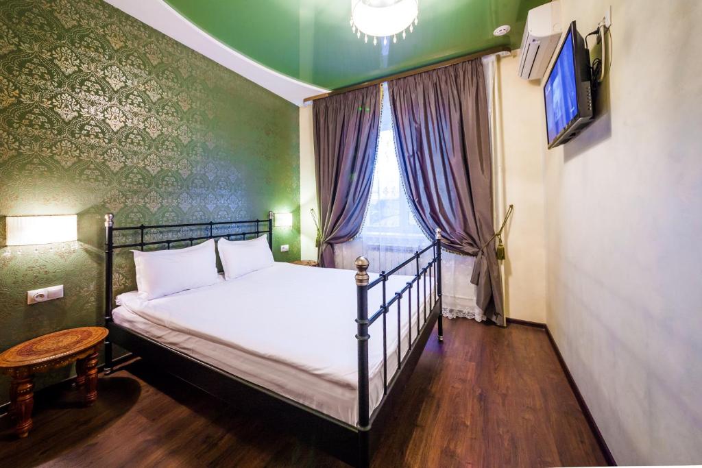 1 dormitorio con 1 cama, TV y ventana en Hotel Khalif, en Tomsk