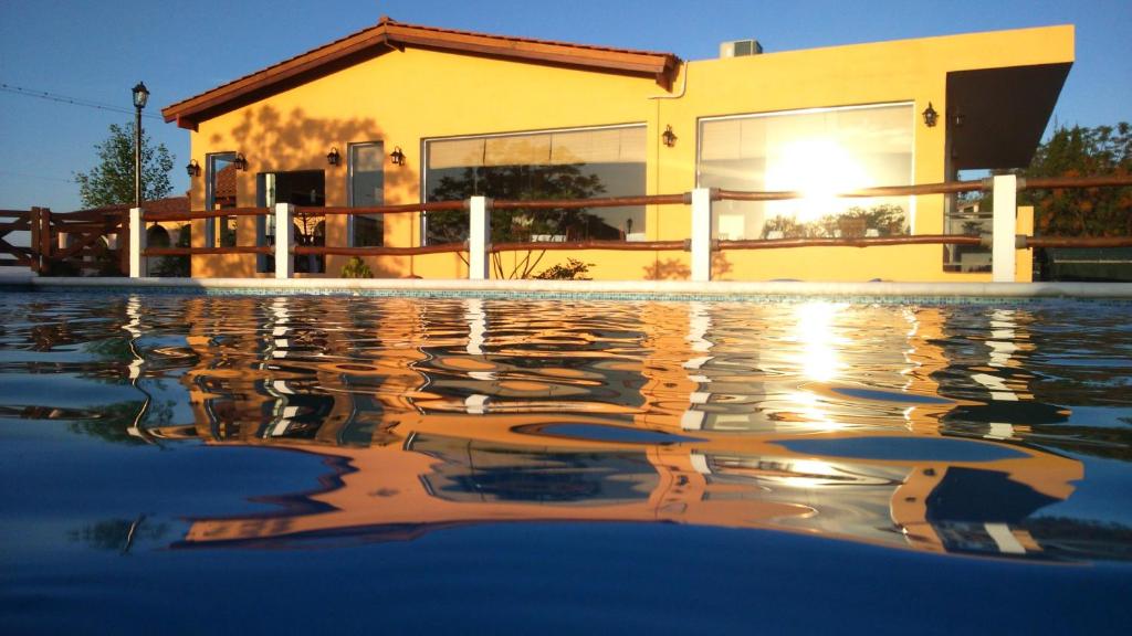 a house with a pool in front of a building at Solar de Piedra in Tanti