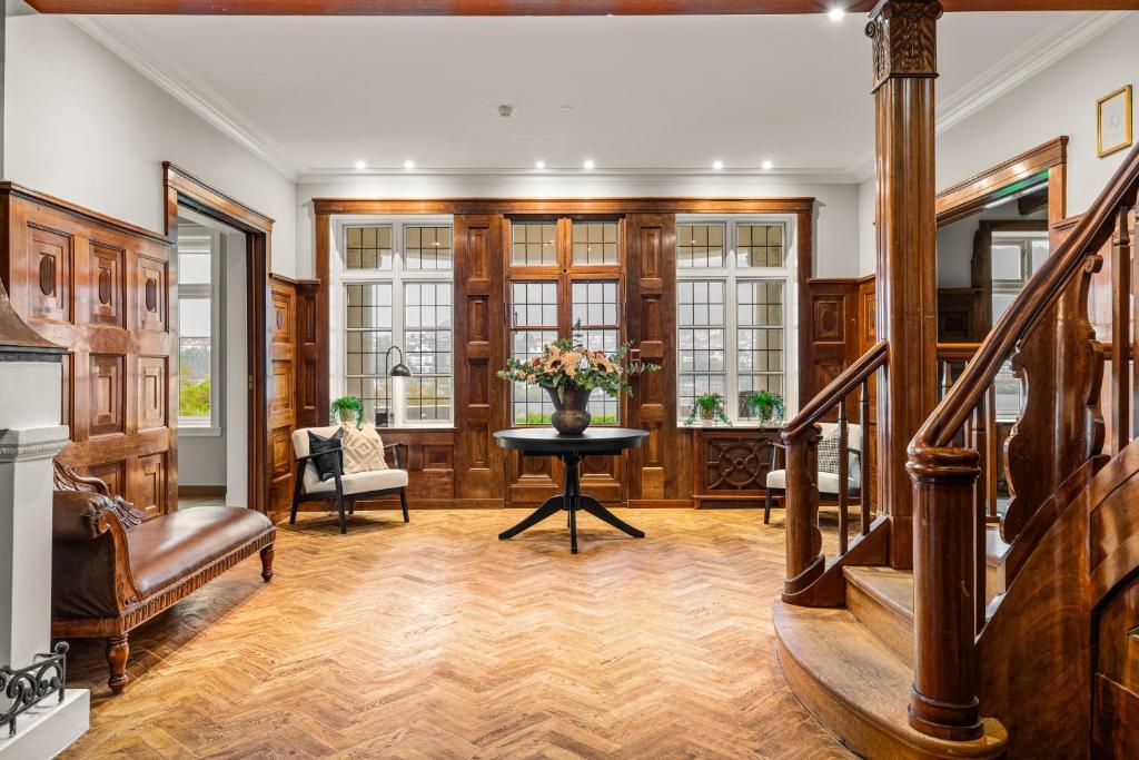 Una sala de estar con una mesa con un jarrón de flores. en Elegant Historic Villa - Stunning Views, en Bergen