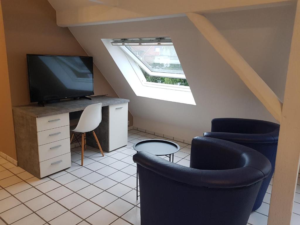 a living room with a tv and two chairs at Gemütliche Zimmer - Messe Gruga in Essen