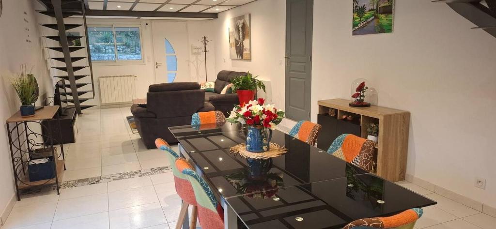 a living room with a table with chairs and a couch at Le Vallon du Garn - Gîte en pleine nature in Laval-Saint-Roman