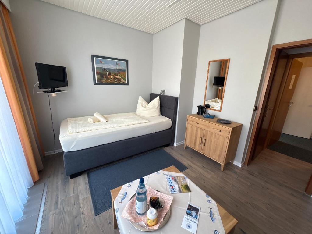 ein kleines Zimmer mit einem Bett und einem Tisch in der Unterkunft Hotel-Restaurant Nord Stuv in Cuxhaven