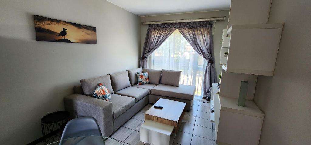 a living room with a couch and a table at Peaceful Casa in Kempton Park