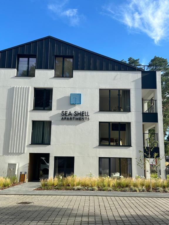 a building with a sign that reads sea shell apartments at Apartamenty Joy Me Łukęcin in Łukęcin