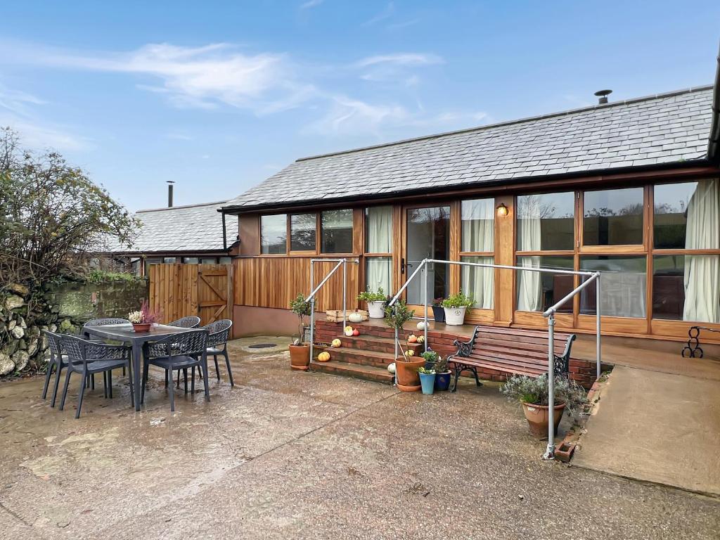 a house with a table and a bench in front of it at Westlands Brendon Hill in Treborough