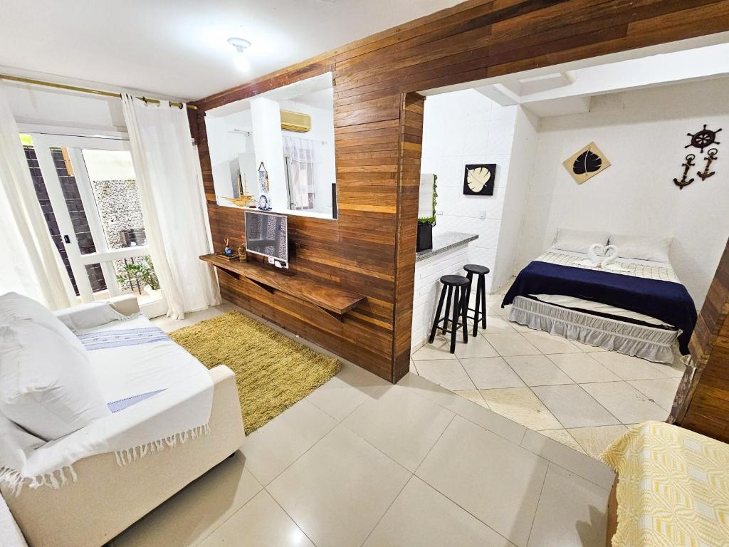 a living room with a bed and a television at CASA COMPLETA 5min DA PRAIA JUQUEHY in São Sebastião