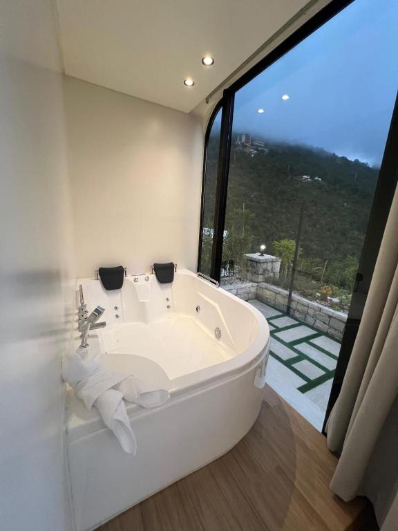 a bath tub in a bathroom with a large window at Sunheaven resort in Al Qarşā