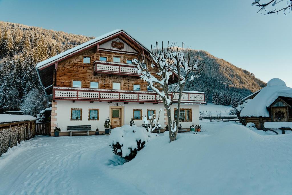 a log cabin in the snow with a tree at Chalet Auhof in Flachau