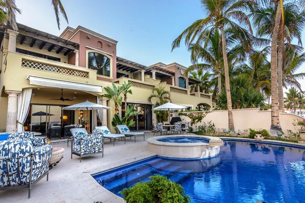 a house with a swimming pool and palm trees at Villa Pura Vida in San José del Cabo