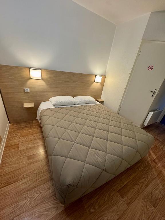 a bedroom with a large bed with two pillows at Première Classe Rennes sud Est in Chantepie