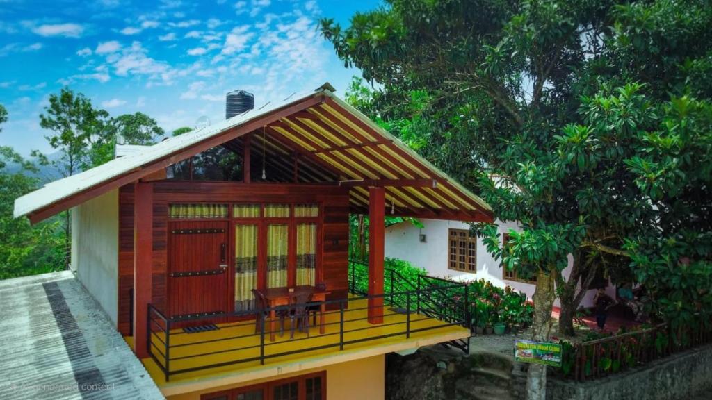 a small house with a porch and a deck at Nine Arch Wood Cabin in Ella