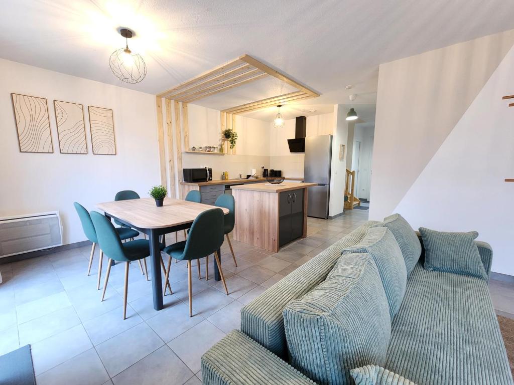 a living room with a couch and a table and a kitchen at Le Plaisance de Mérignac in BOD