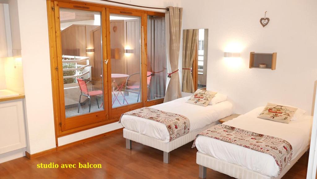 Una habitación con dos camas y una silla dentro. en Le Grand Chalet - Le Studio, en Brides-les-Bains