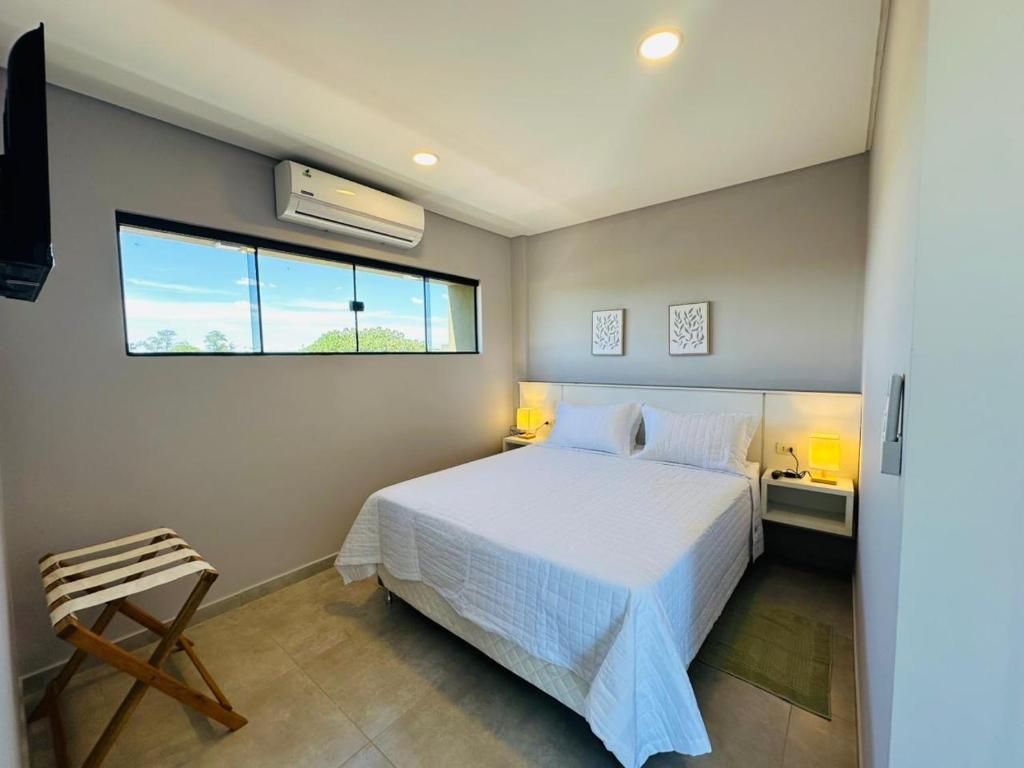 a bedroom with a white bed and a window at Alojamiento Del Lago in Cambyretá