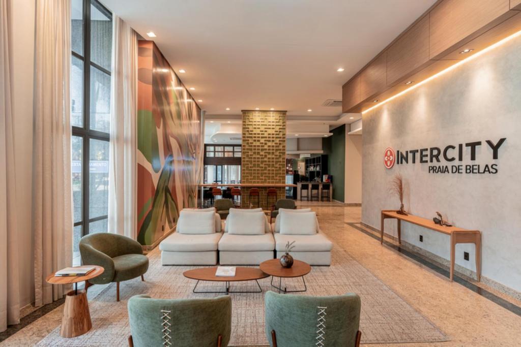 a lobby with a waiting area with couches and chairs at Intercity Porto Alegre Praia de Belas in Porto Alegre