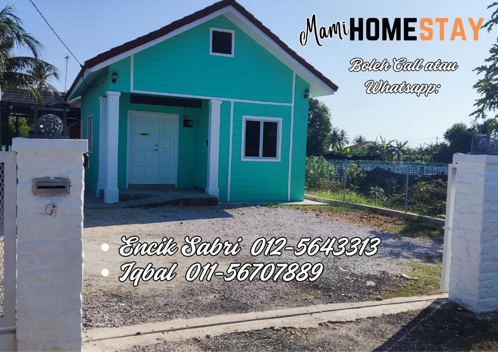 een huis met een blauwe garage met de tekst "draft home stay" bij Mami Homestay in Alor Setar