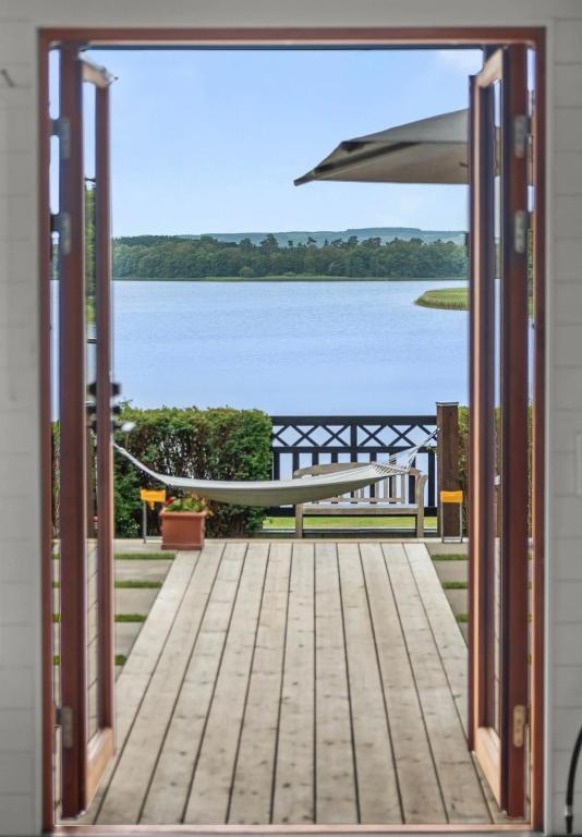 an open door to a deck with a view of a lake at Sjöutsikt Sövde in Sövde