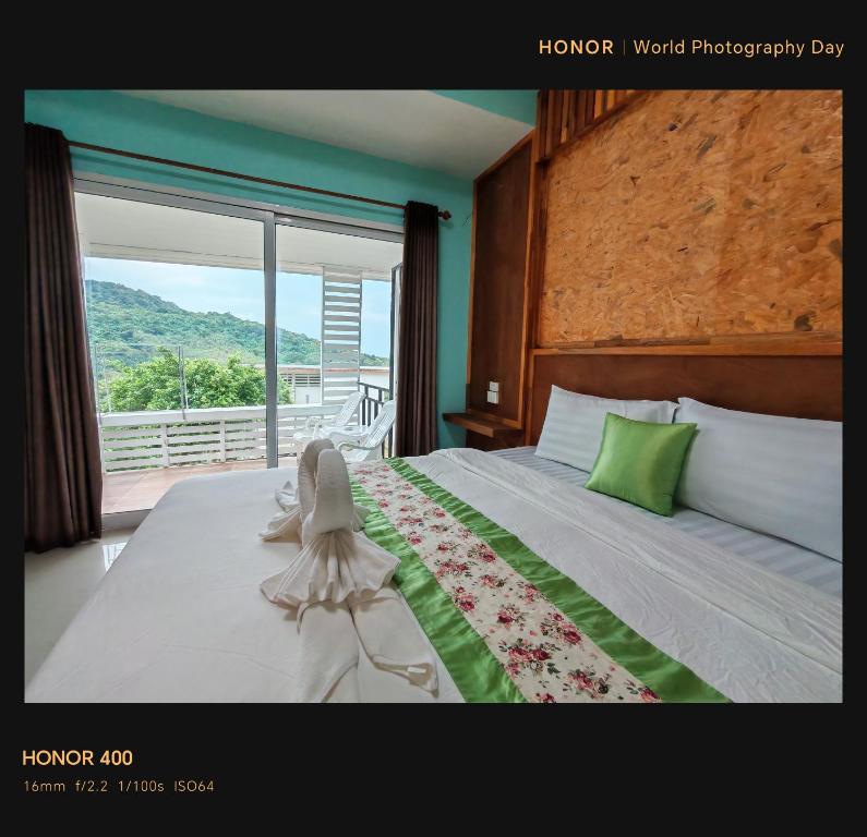 a bedroom with a bed and a large window with a view at Phulanta Resort in Ko Lanta Yai