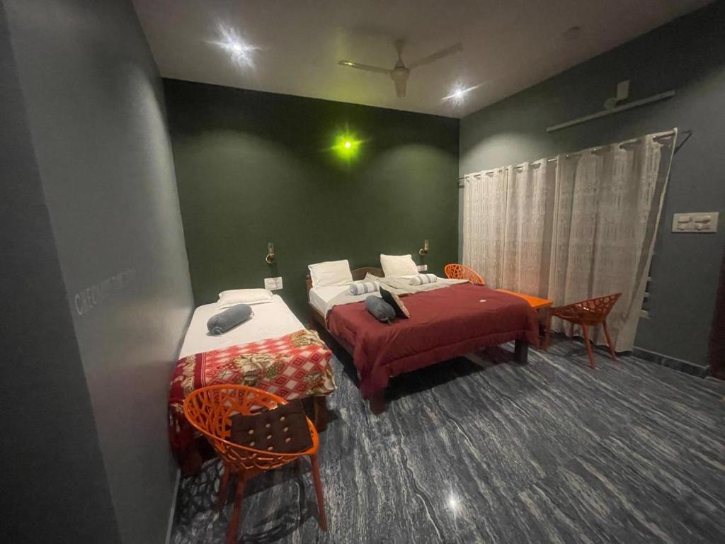 a bedroom with a bed and a table and chairs at Budha Home Stay in Hampi