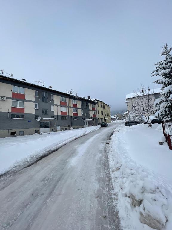 an empty street covered in snow with buildings at Apartman Ivano Kupres in Kupres