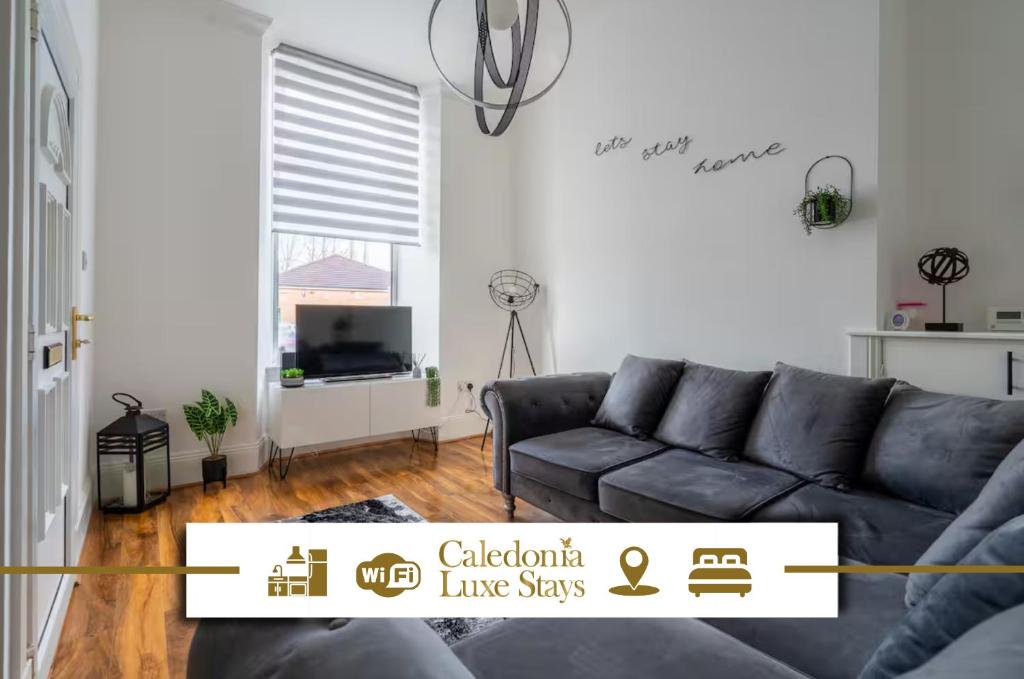 a living room with a couch and a television at Coatbridge Apartment in Coatbridge