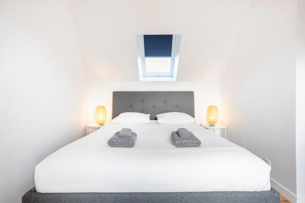a bedroom with a white bed with two shoes on it at Ty Sterenn - 400m de la plage in Le Guilvinec