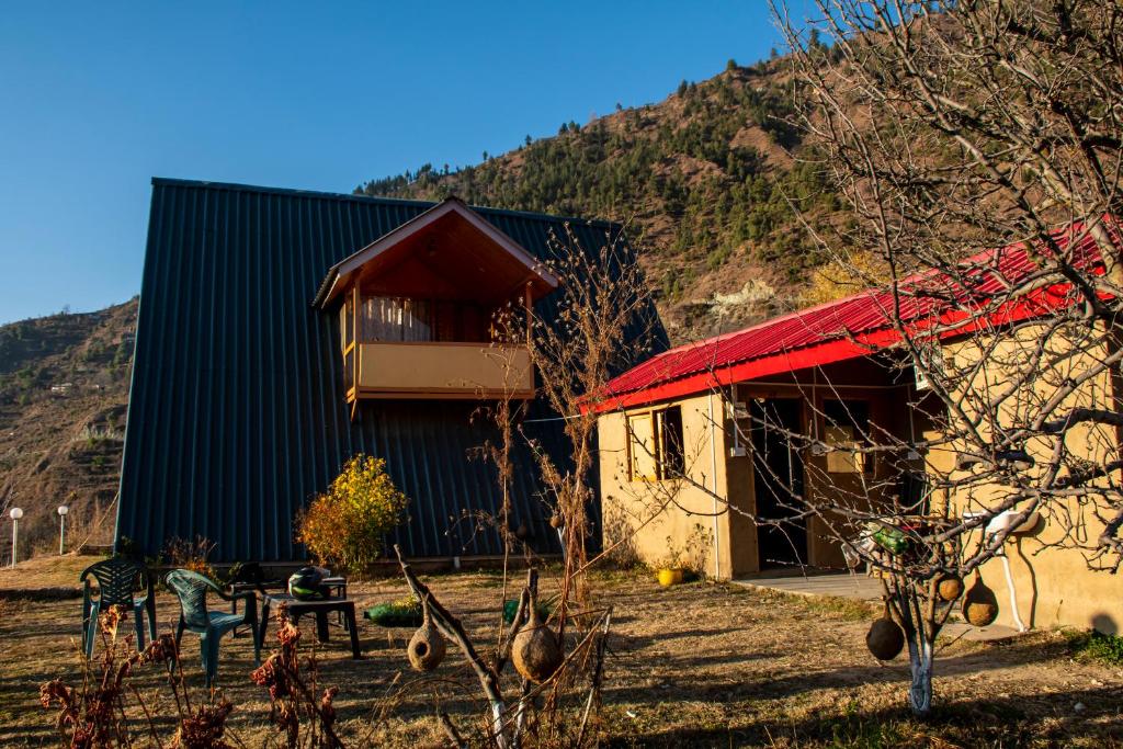 un edificio con techo rojo al lado de una montaña en Palach Kothi, en Banjār
