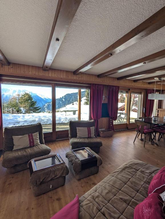 a living room with couches and a large window at Appartement-chalet à Verbier près des pistes in Verbier