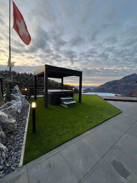 a gazebo on a lawn with a flag at Villa Tauris in Emmetten