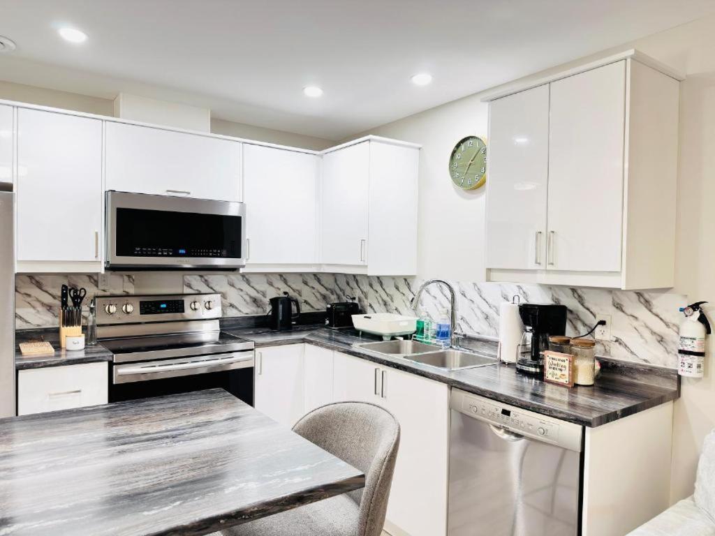a kitchen with white cabinets and a counter top at Moon's Suite near the New Hospital in Corner Brook