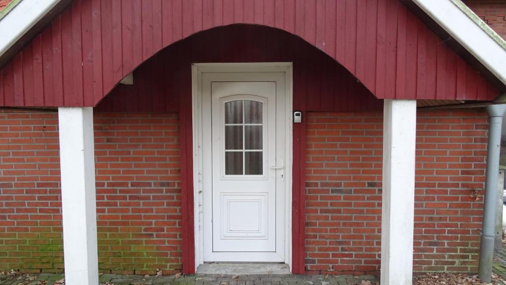 a red brick building with a white door at Overlinger Gästehaus in Westoverledingen