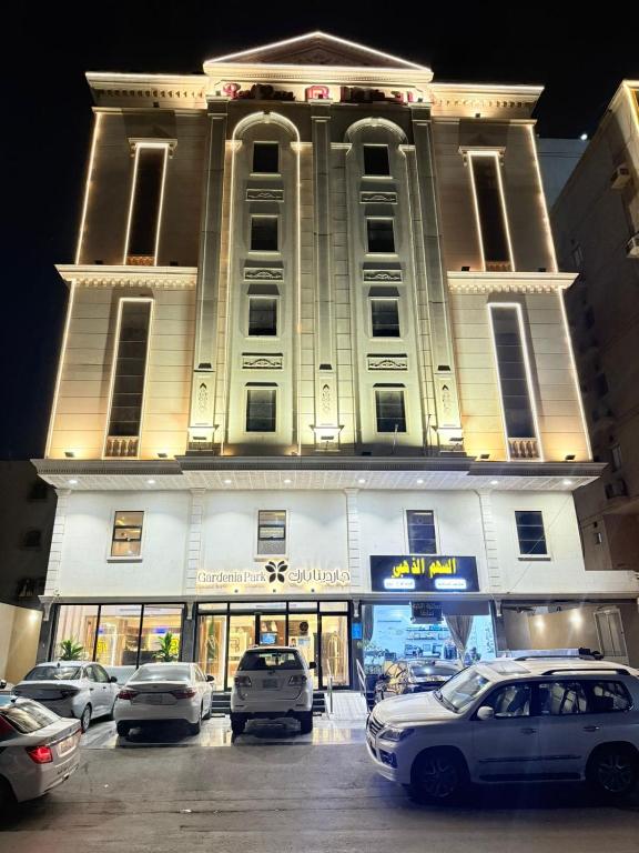 a large building with cars parked in front of it at Gardenia Park Al Rawabi Serviced Apartments Economyجاردنيا بارك الروابي للشقق المخدومةاقتصادي in Quwayzah