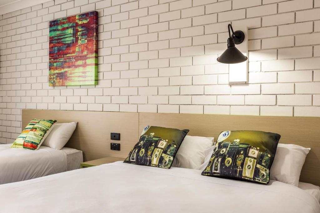 a bedroom with two beds and a painting on the wall at Boomerang Hotel in Albury