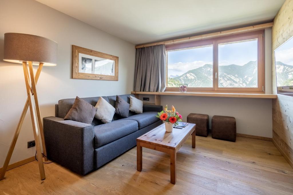 a living room with a couch and a table at SWISSPEAK Resorts Vercorin in Vercorin