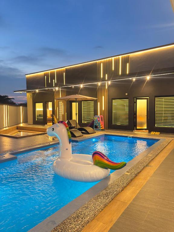 a swimming pool with a unicorn float in a house at LYL 108 Private Pool Villa in Ipoh