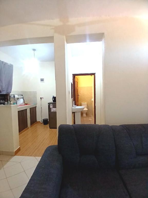 Una sala de estar con un sofá y una cocina. en Escaped Diani, en Diani Beach
