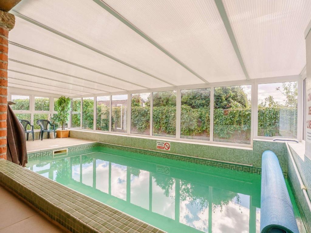 an indoor swimming pool with a large room with windows at 2 Bed in Newton-on-Rawcliffe 88955 in Newton
