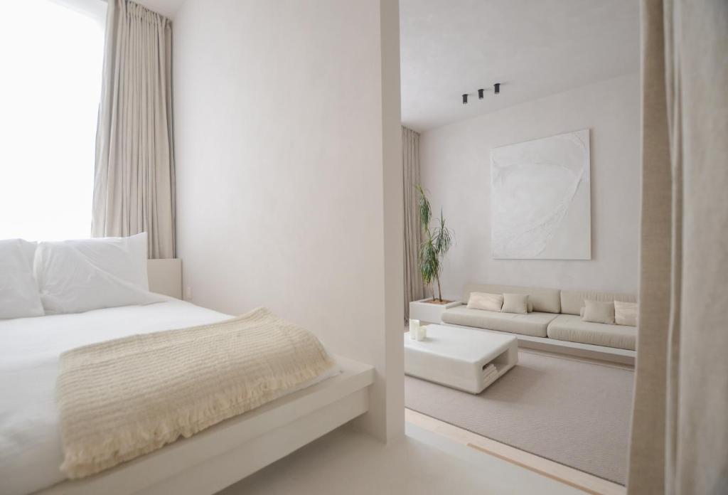 a white bedroom with a bed and a couch at Luxurious 1BR Apartment with Parking in Antwerp
