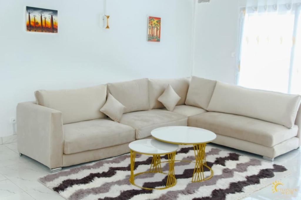 a living room with a white couch and a table at Maison moderne et spacieuse 9 min Ivato aeroport 