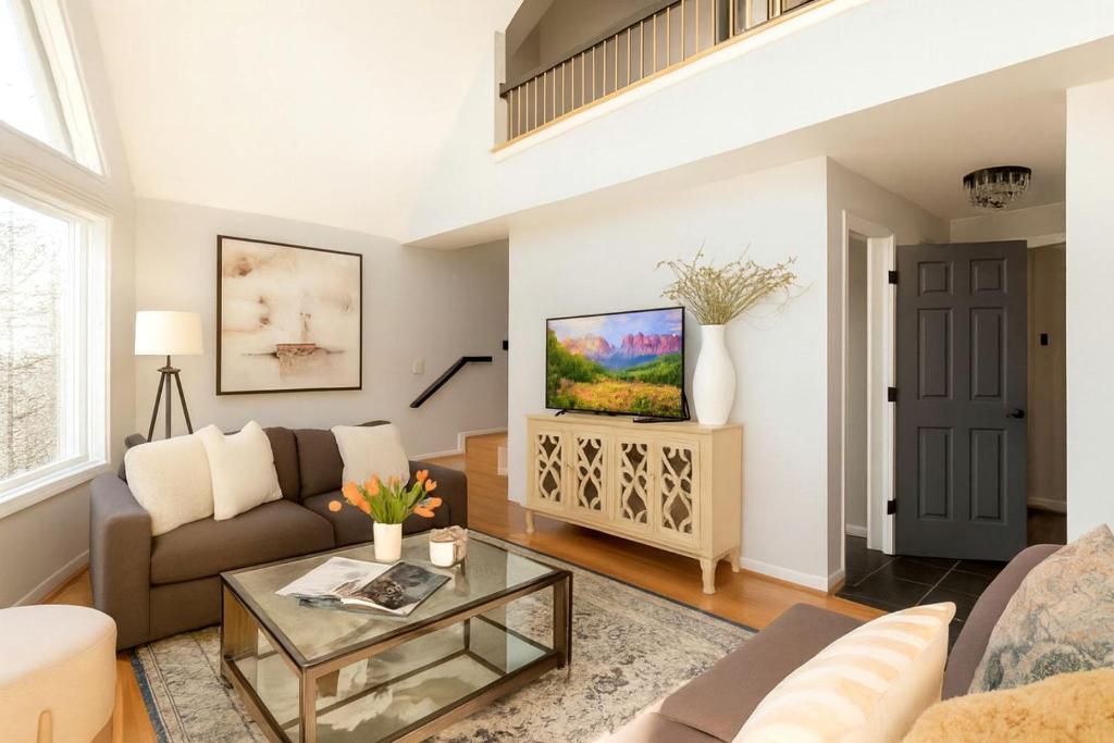 Waterfront Retreat with Spectacular Interior, Jacuzzi and Game Room in NC في East Monbo: غرفة معيشة بها أريكة وطاولة