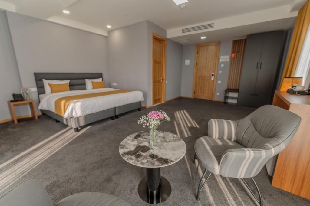 ein Hotelzimmer mit einem Bett und einem Tisch und Stühlen in der Unterkunft Burki Castle & Cellar in Qwareli