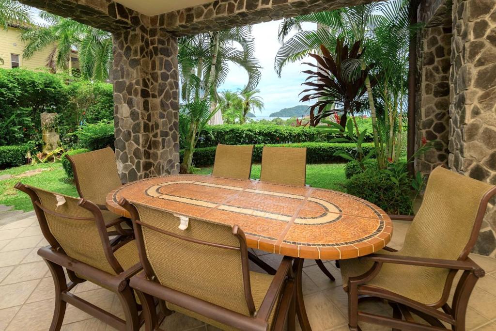 a wooden table and chairs on a patio at Vista Bahia 1G - 3bed 3 bath Ocean View in La Mona