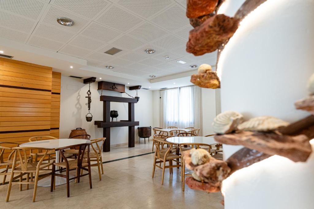 a restaurant with tables and chairs in a room at Hotel Rural El Majuelo in Montorio