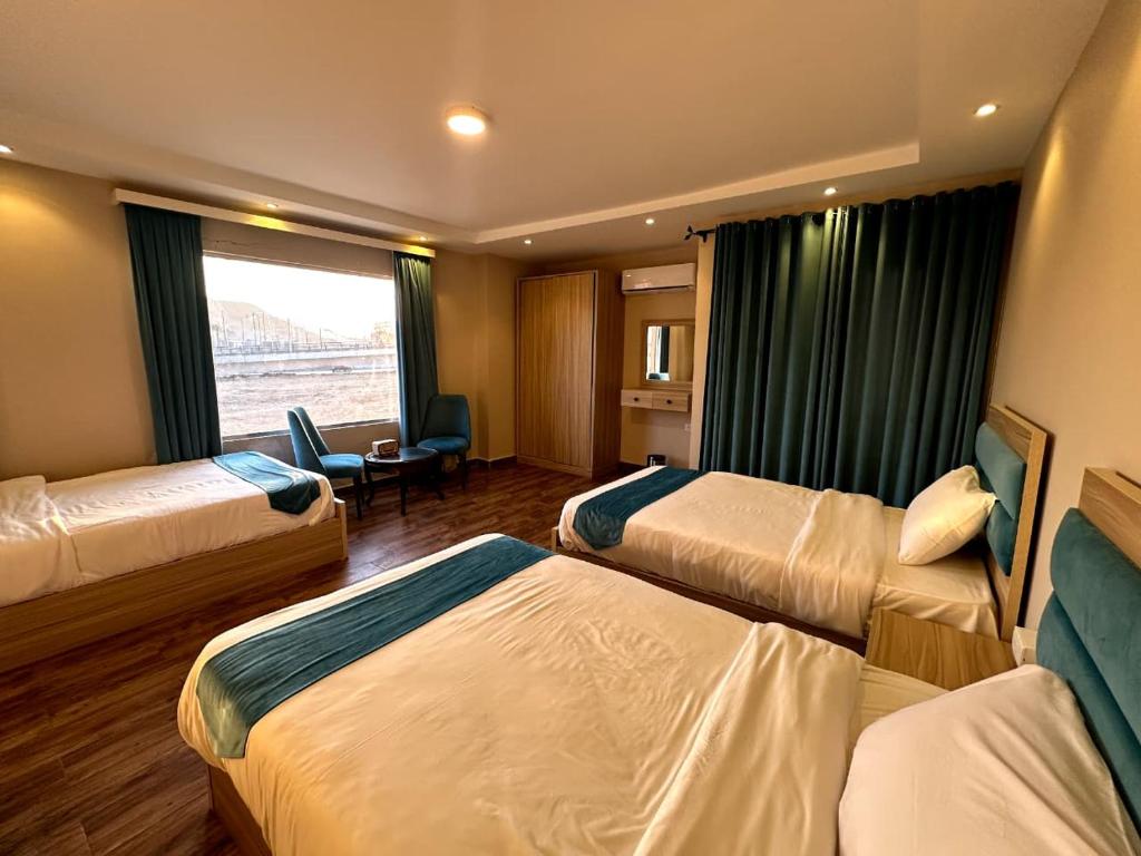 een hotelkamer met 3 bedden en een raam bij Gabry Pyramids And Grand Egyptian Museum View Hotel in Caïro