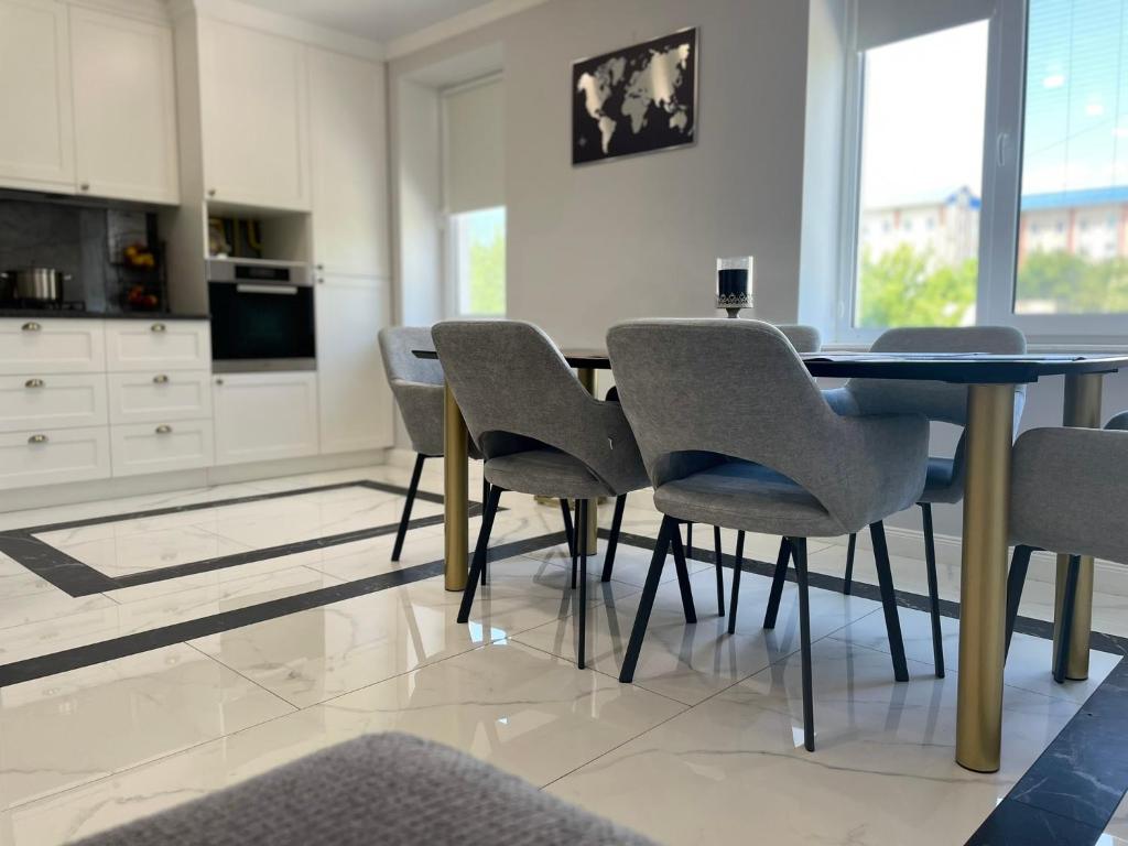 CăuşeniにあるApartament modernのテーブルと椅子のあるダイニングルーム