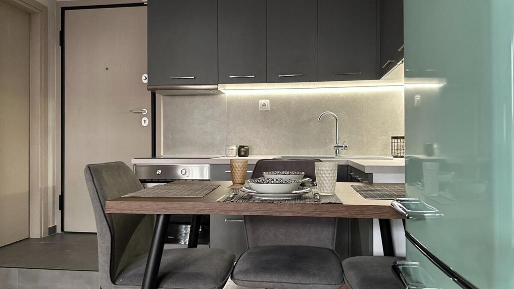 a kitchen with a table with chairs and a sink at Casa Aphrodite Thessaloniki in Thessaloniki