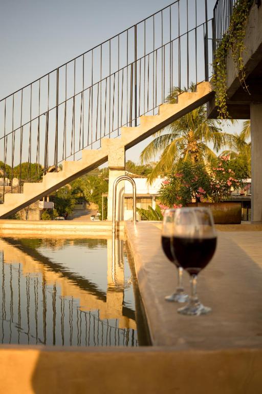 a glass of wine sitting on a table next to a pool at Casa Ampa Zikatela- Brisas de Zicatela- Puerto Escondido in Brisas de Zicatela