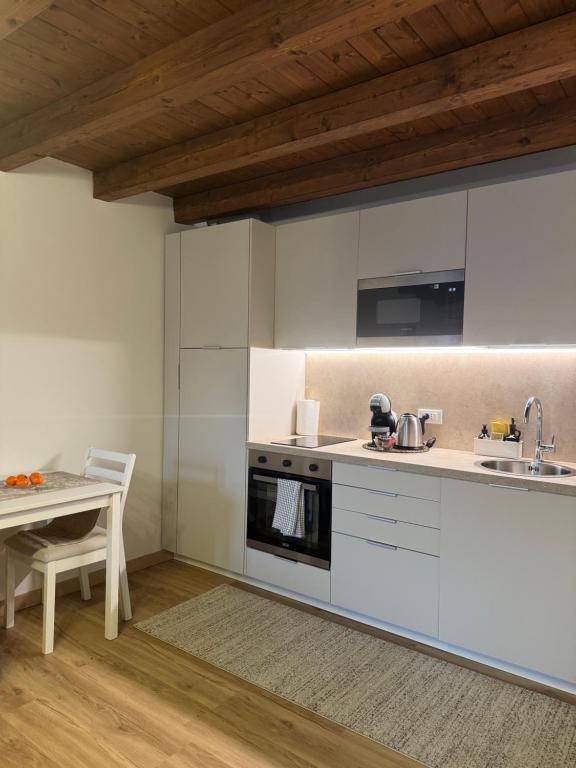 a kitchen with white cabinets and a table at casa duomo vicenza in Vicenza